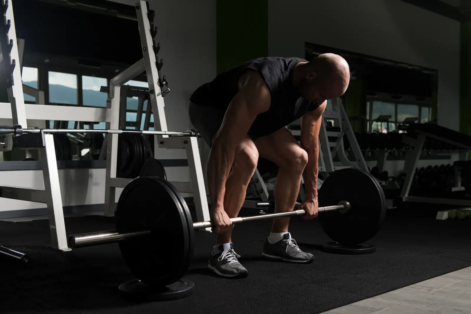 სპორტსმენი asრულებს trap bar deadlift-ს სპორტზალში სწორი ტექნიკით